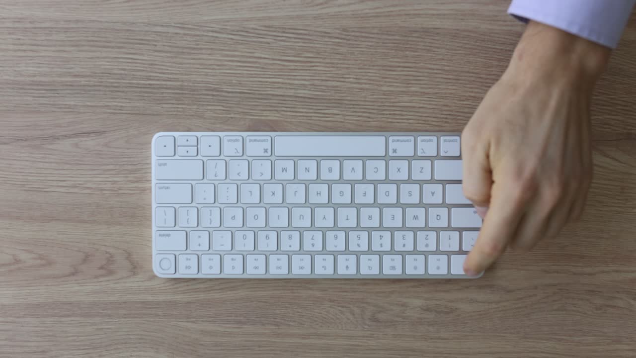 Programmer presses button on keyboard on wooden table