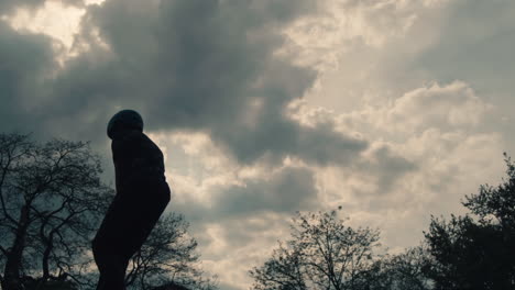 silhouette of a teenager on a scooter unsuccessfully trying a trick in the air