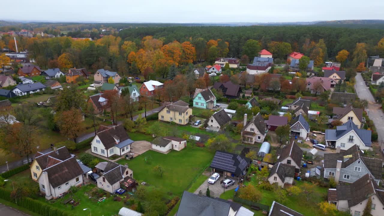 Drone vipper op fra landsbyhus til grønt skovlandskab i et afsidesliggende område.