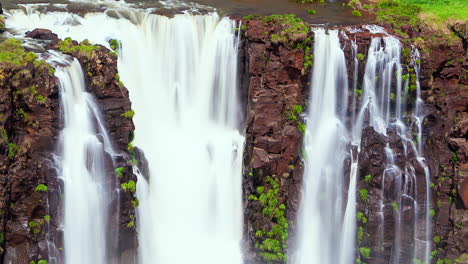 el lapso de tiempo de las cascadas de iguazu, entre una pared de rocas, en un día soleado, foz do iguacu, parana, brasil