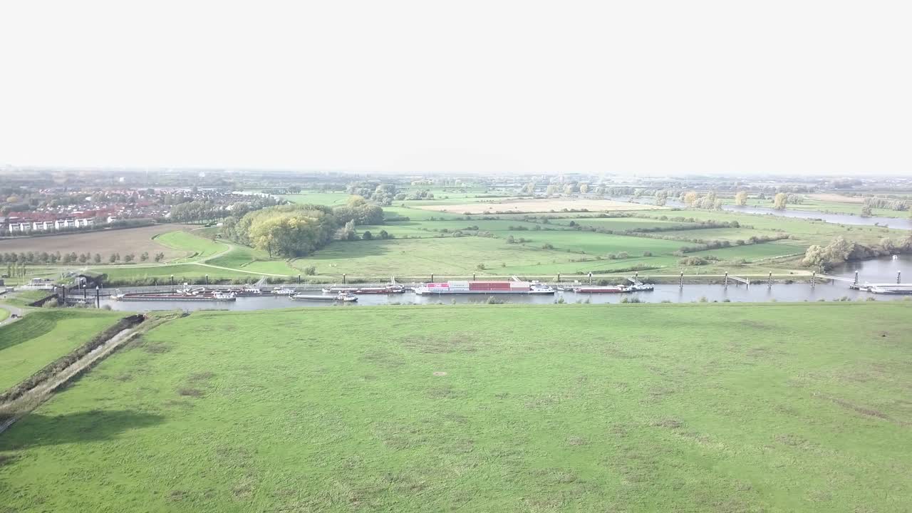 네덜란드의 화물선과 함께 운하 근처의 녹색 농장 필드의 드론 샷