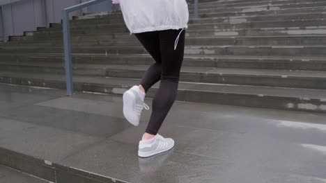 mujer joven vestida con ropa deportiva corriendo escaleras arriba como ejercicio para su rutina de ejercicios