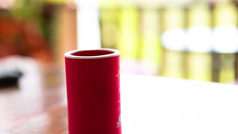 mano colocando una lata en un refrigerador rojo