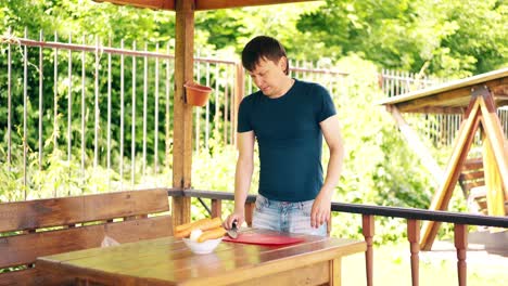 guy is cooking pilaf is in the summer house preparing for a picnic he gestures that he has finished cooking