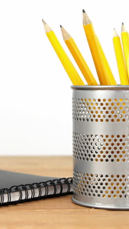 close-up of pen holder with pencil and diary