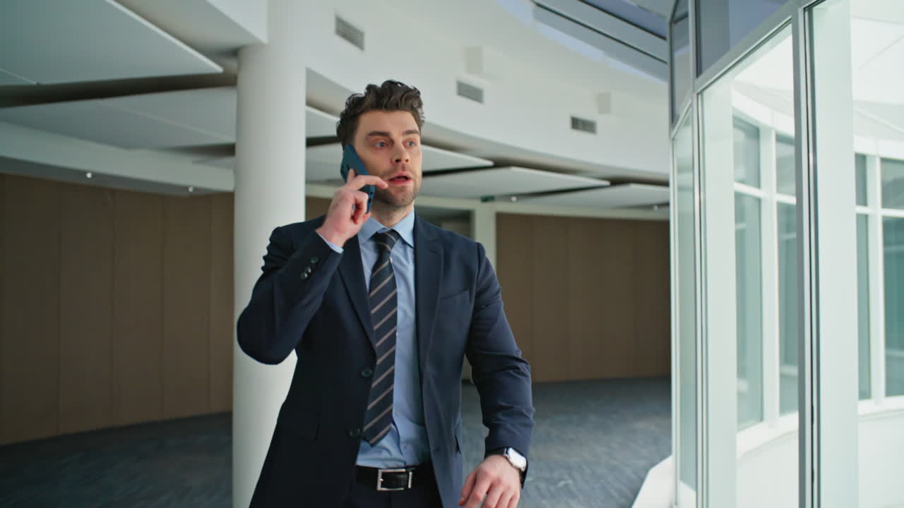 Entrepreneur talking cellphone walking office corridor closeup. Manager call