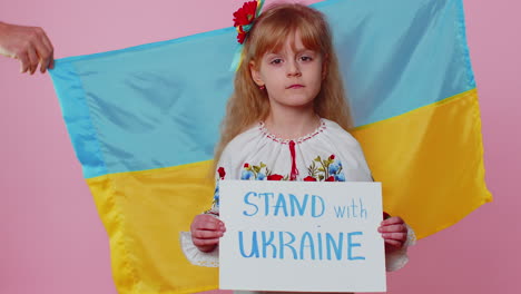 sad toddler ukrainian girl kid in embroidery protesting war conflict raises banner with inscription