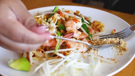 person eating pad thai