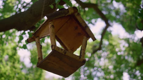 Vogelhäuschen-Hängt-Am-Baum-Im-Sonnenlicht-Aus-Nächster-Nähe.-Niedliches-Vogelhaus-Im-Park