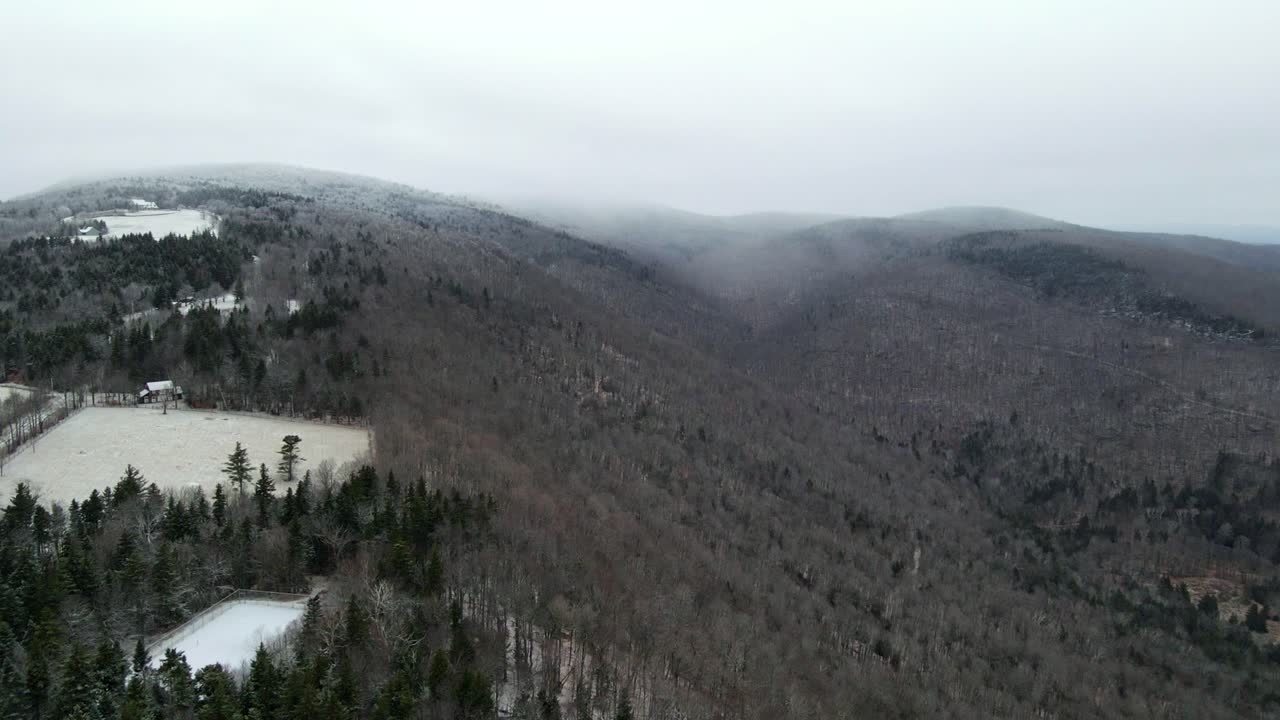 una foto de un dron de una nube de nieve nevando en las montañas en vermont, nueva inglaterra, estados unidos