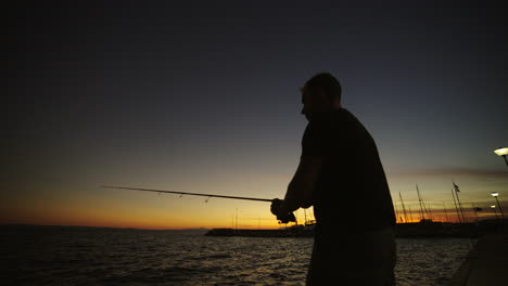 silhouette of a man fishing at sunset