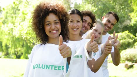 volunteers standing in a row giving smiling at camera