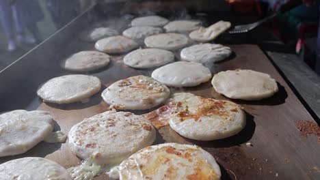 pupusas a traditional salvadoran food being cooked in hot griddle close up