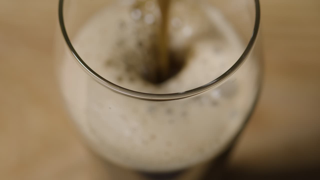 성 패트릭의 날 2를 기념하기 위해 블랙 스튜디오 배경에 대해 유리에 아일랜드 스타우트 파인트를 붓고 있습니다.