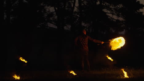 fire performer at night in a forest