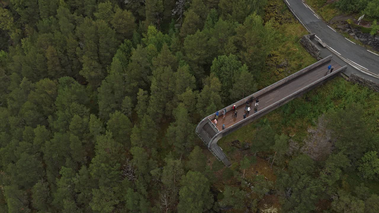 Tourists enjoy panoramic fjord views at Norway's Stegastein lookout, drone aerial shot