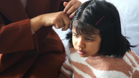 mother combing daughter's hair