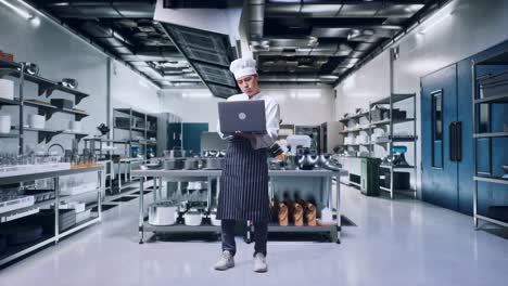 chef trabajando en una computadora portátil en la cocina de un restaurante