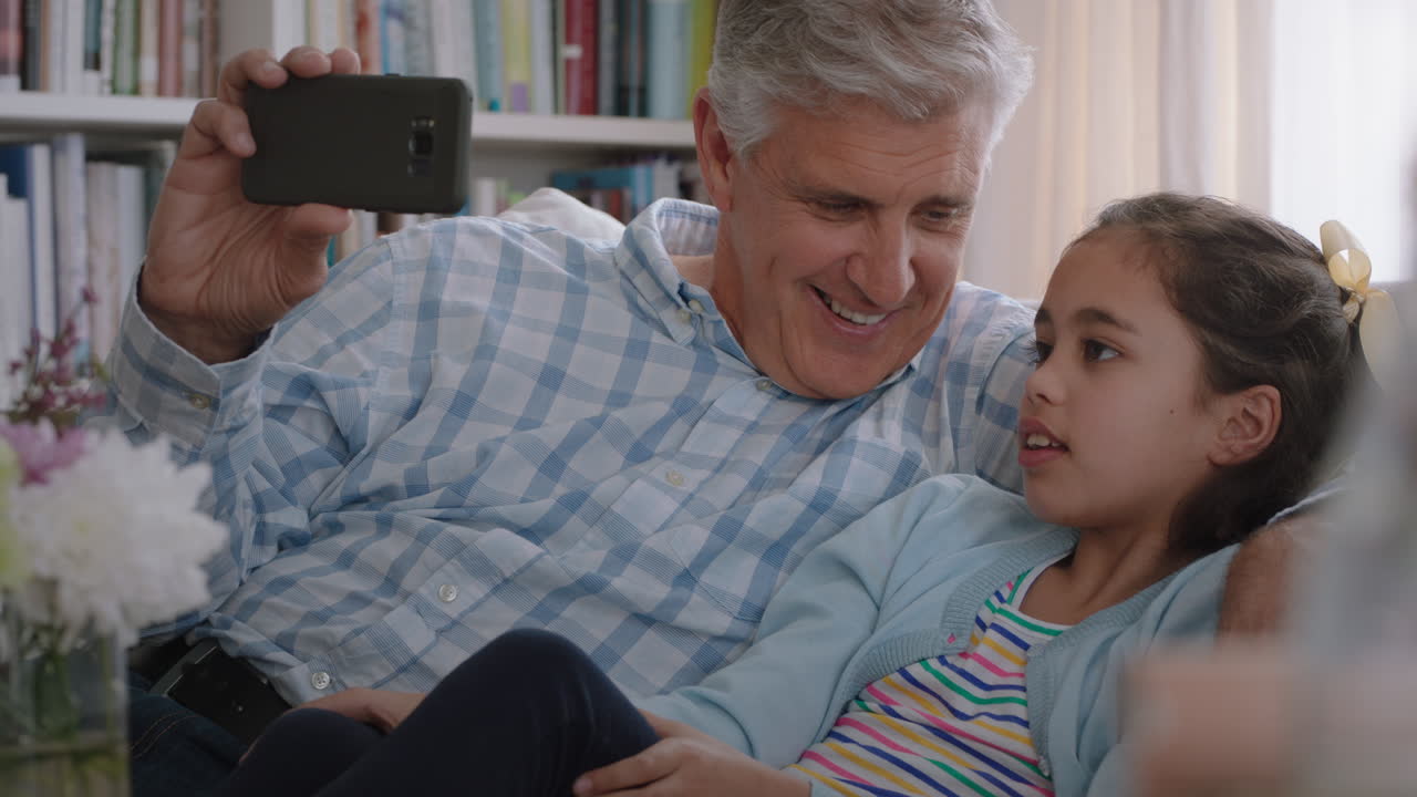 abuelo e hijo chateando por video usando un teléfono inteligente niña pequeña compartiendo el fin de semana de vacaciones con la familia abuelo disfrutando de chatear en la tecnología móvil en casa con la nieta