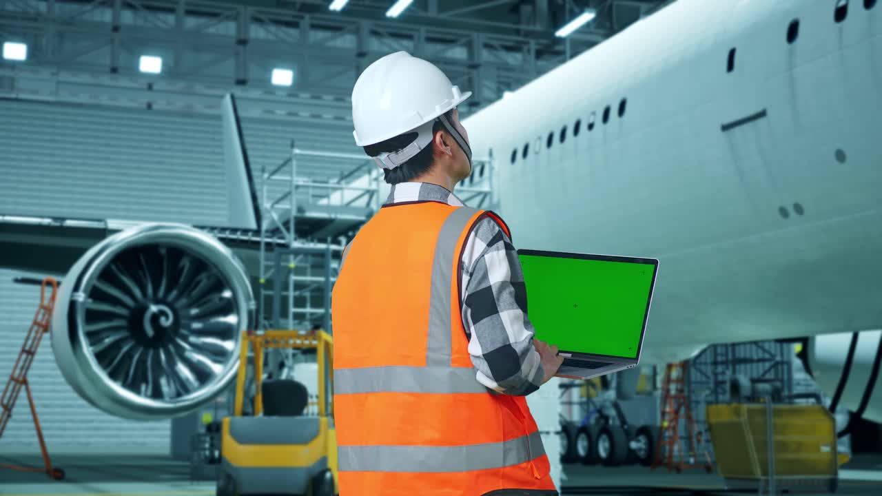 técnico de mantenimiento de aeronaves con computadora portátil en el hangar