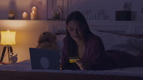 woman shopping online in bed at night