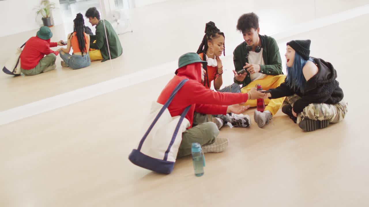 행복한 다양한 남녀 댄서들이 댄스 스튜디오에서 스마트폰을 사용하고 이야기하고, 슬로우 모션