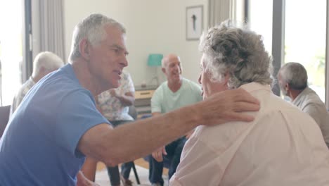 Diverse-seniors-talking-and-embracing-in-emotional-group-therapy-session,-unaltered,-slow-motion