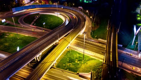 Vista-Aérea-Nocturna-De-Timelapse-De-Una-Intersección-De-Autopistas-Con-Senderos-De-Tráfico-En-Moscú-Nocturna