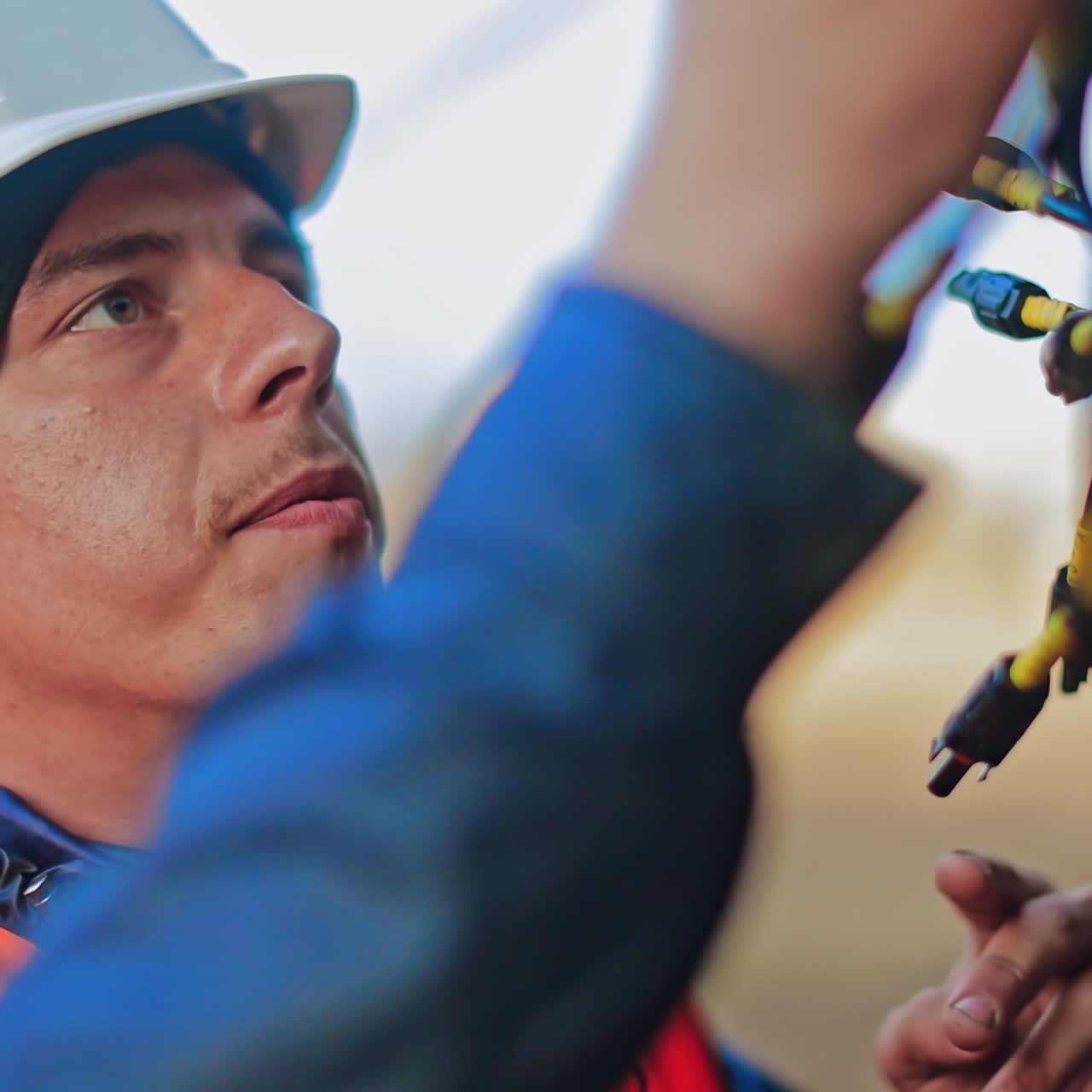 Engineering works. Mechanic in hard hat working outdoors. Portrait of young male builder at work.