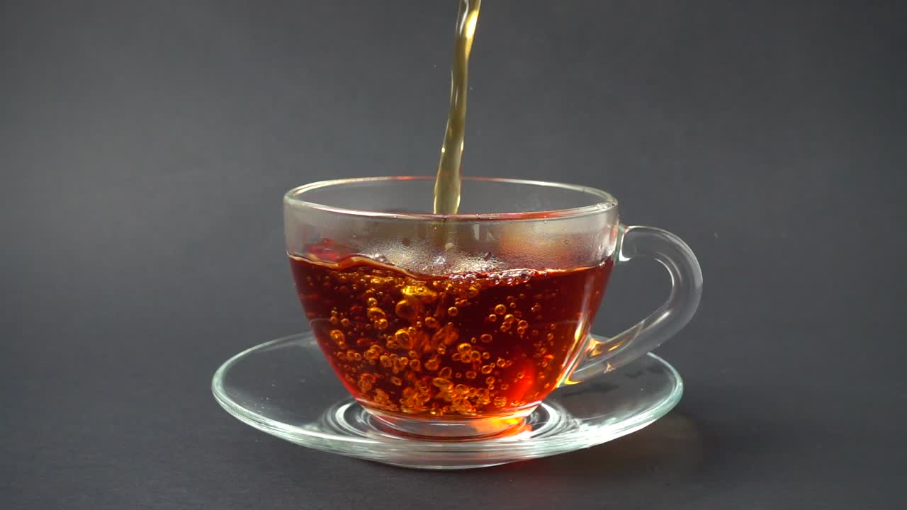 Il tè viene versato nella tazza. Movimento rallentato