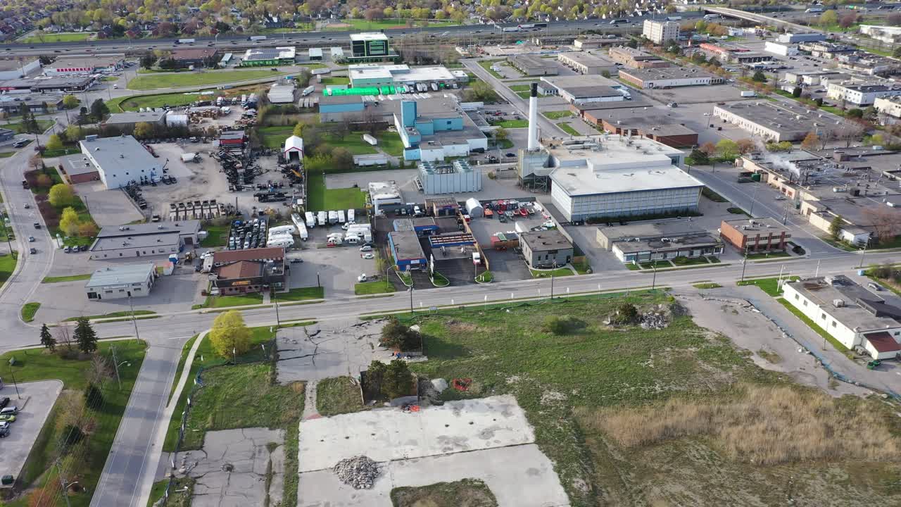 Vista aérea sobrevoando um distrito comercial e industrial com armazéns, fábricas e edifícios comerciais sob um céu limpo. Em Ajax, Ontário, Canadá.