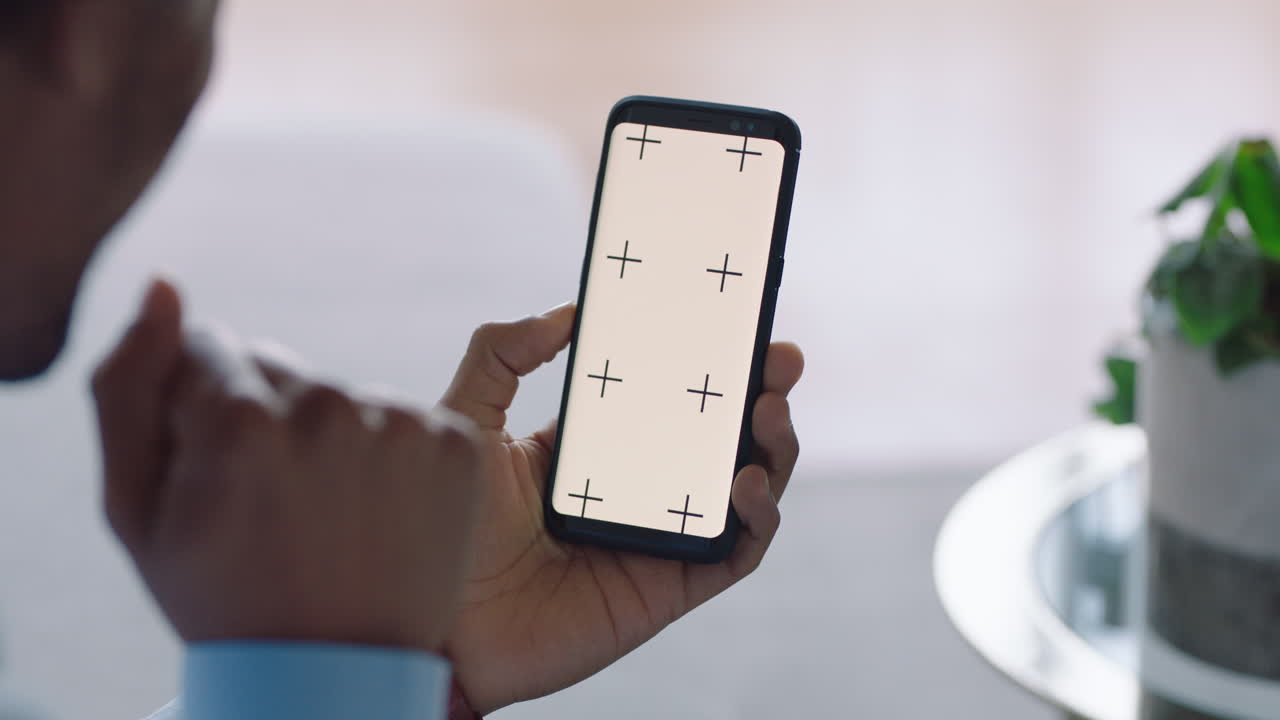 스마트 폰을 사용하는 행복한 남자가 비디오 채팅을 하고 녹색 화면에서 아기에게 손을 흔들고 모바일 통신을 즐기고 수직 방향으로 크로마 키 디스플레이를 표시합니다.