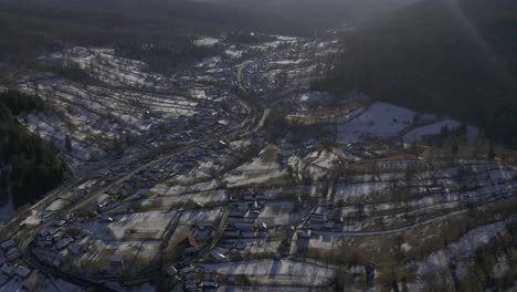 drone view of village in valley below mountains