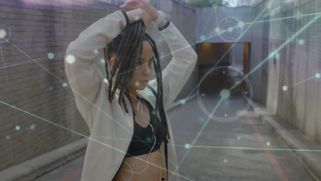 Tying hair, woman in sportswear with network connections animation over urban background