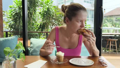 mujer disfrutando de café y pasteles en un café
