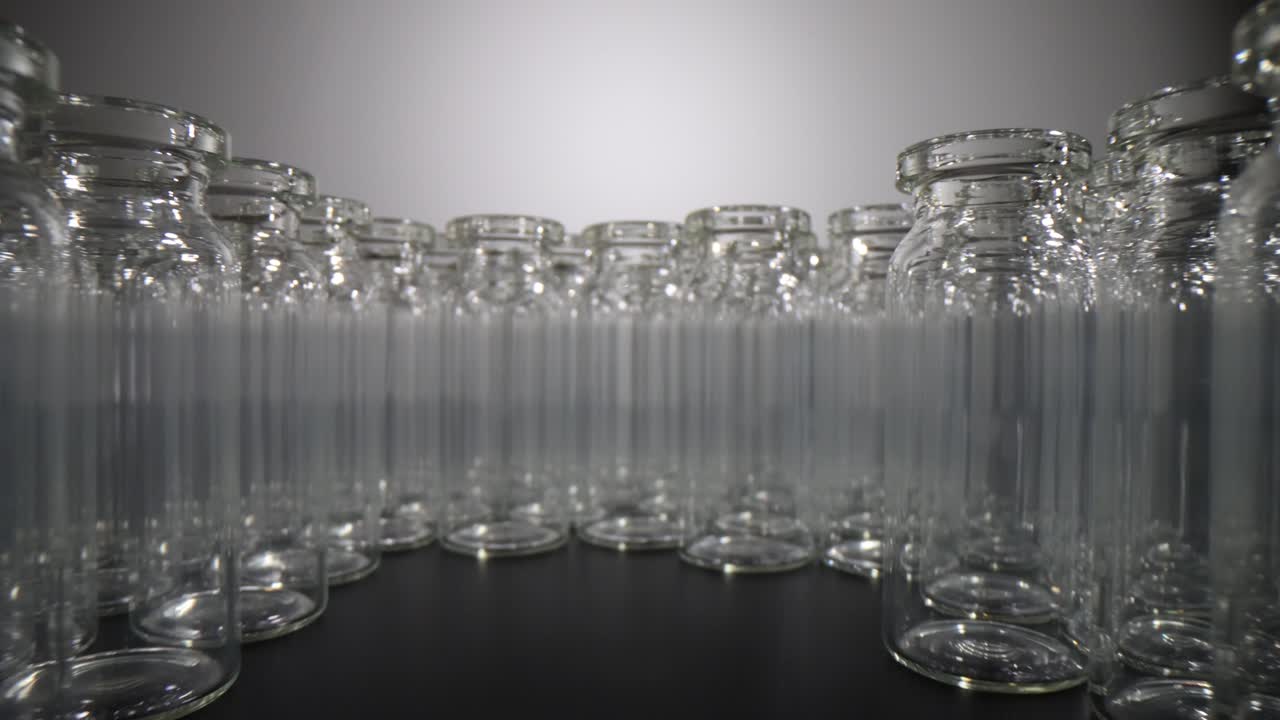 Rows of Clear Empty Glass Vials Arranged on a Dark Surface