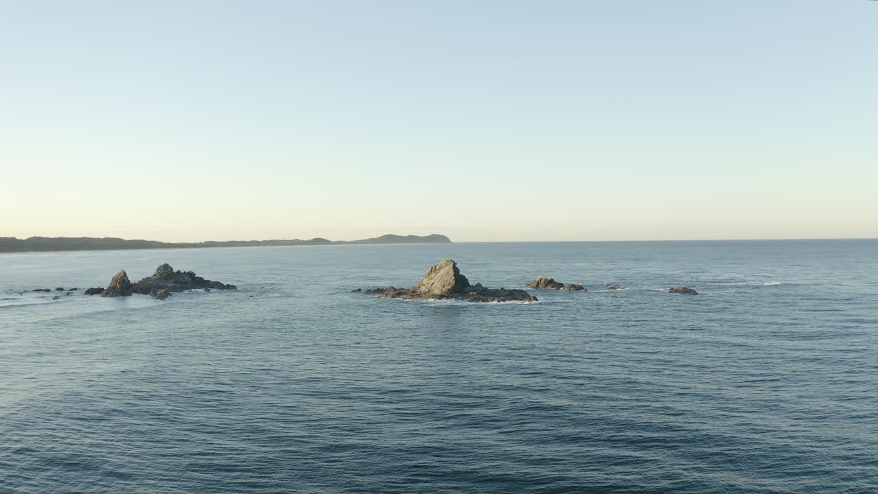 일몰 동안 호주 바이런 베이 외곽에 있는 작은 외로운 섬의 4k 드론 샷