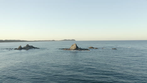 4k drone shot of a small lonely island outside byron bay, australia during sunset