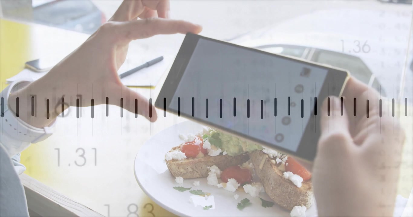 アボカドトーストに気づき、スマートフォンを持ち上げて回転させながら、グリッドをタップして構図を合わせる手元。