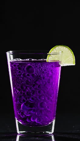 purple drink with lime slice and bubbles