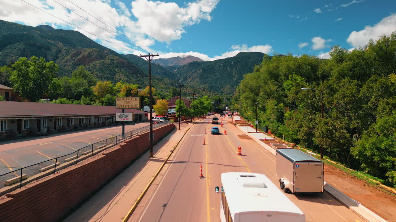 Rekaman video di atas mobil yang melaju di jalan yang dipenuhi tanaman hijau subur. Bebatuan indah sebagai latar belakang. Colorado, AS
