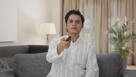 indian man trying to fix tv remote