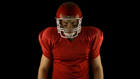 red serious american football player posing
