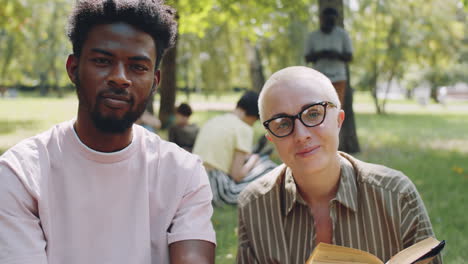 portrait of caucasian teacher and african student in park