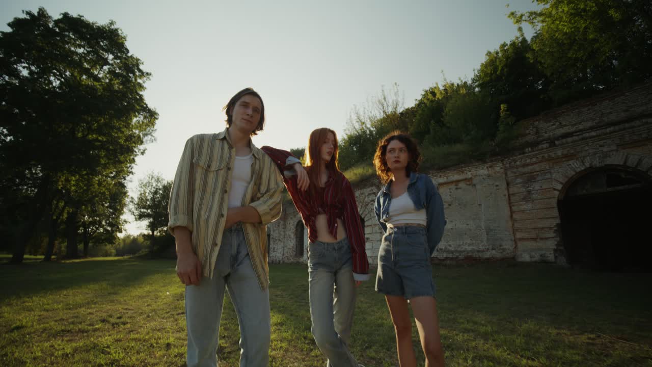 amigos posando al atardecer cerca de viejas ruinas