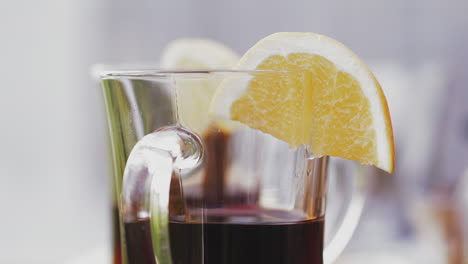 barman puts glass with delicious red mulled wine on table