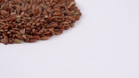 raw red rice on the turn table isolated on white background.