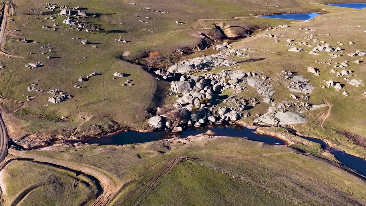 Ujęcie z drona z wysokiej perspektywy granitowych formacji skalnych i wijącego się strumienia w Uralla w Australii