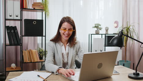 Mujer-De-Negocios-Feliz-Trabajando-En-Una-Computadora-Portátil-En-El-Escritorio-De-La-Oficina-En-Casa-Poniéndose-Auriculares-Escuchando-Música-Relajarse