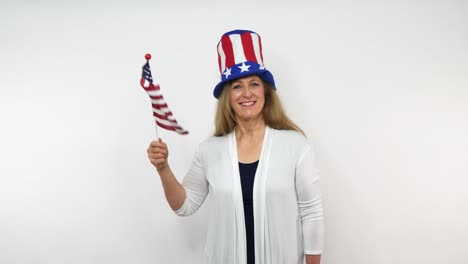 a senior woman waves a flag in celebration of patriotic feelings while wearing a hat with stars, and stripes of red white and blue